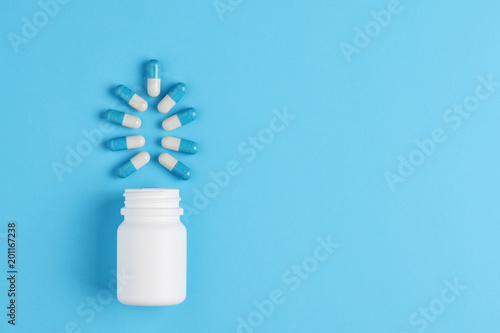 Pharmaceutical medicine pills, capsules and bottle on blue background. Copy space for text