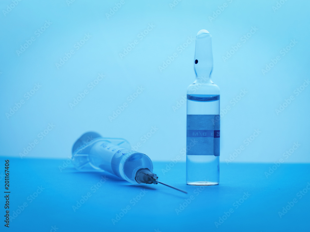 Syringe and ampoule on blue background Syringe and ampoule on blue background