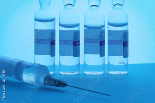Syringe and ampoules on a blue background