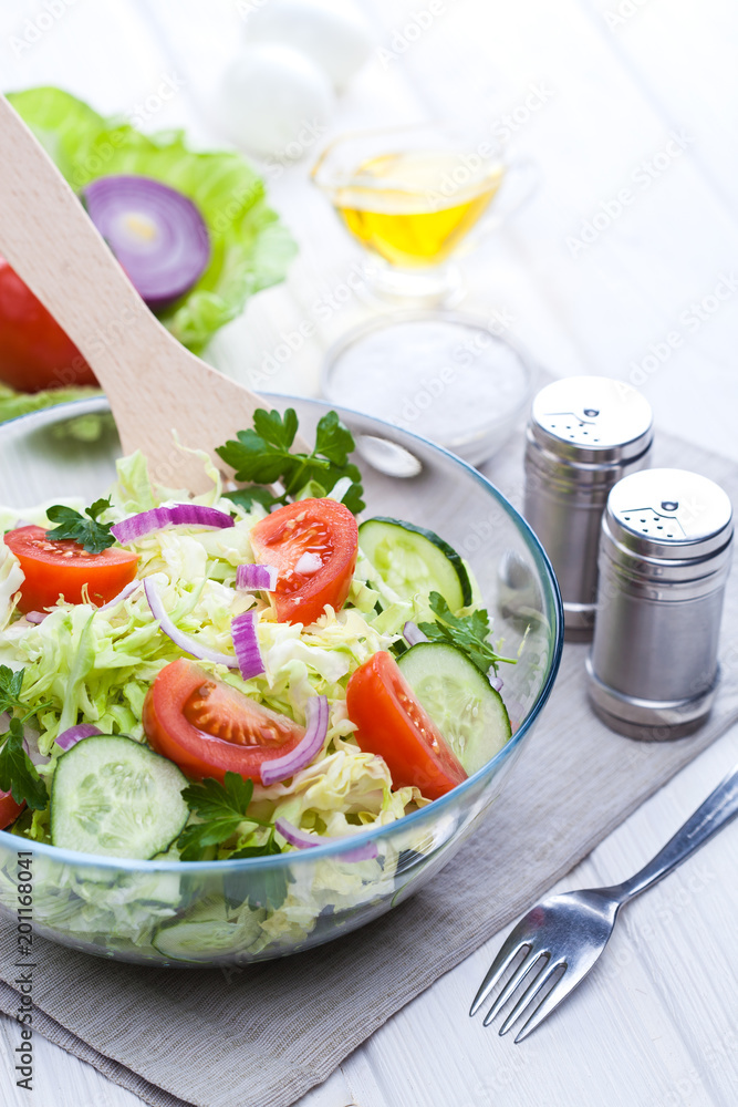 fresh spring salad of vegetables on a white wooden table. fresh spring salad of vegetables on a white wooden table.