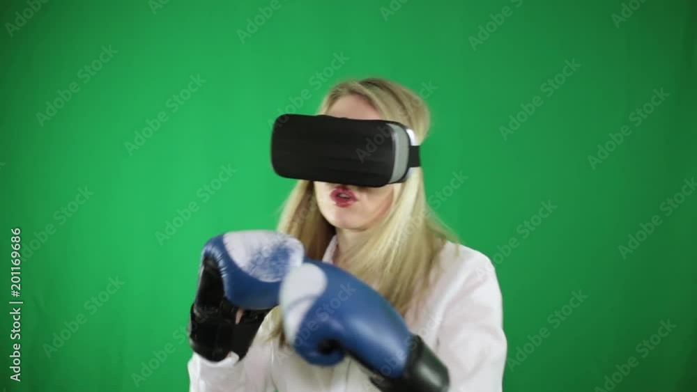 A woman with virtual reality glasses and boxing gloves. A woman with virtual reality glasses and boxing gloves.