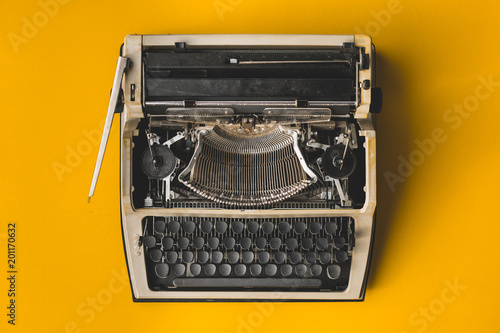 Old Retro Typewriter On A Yellow Background, Top View. Creative Journalism Blogger Concept