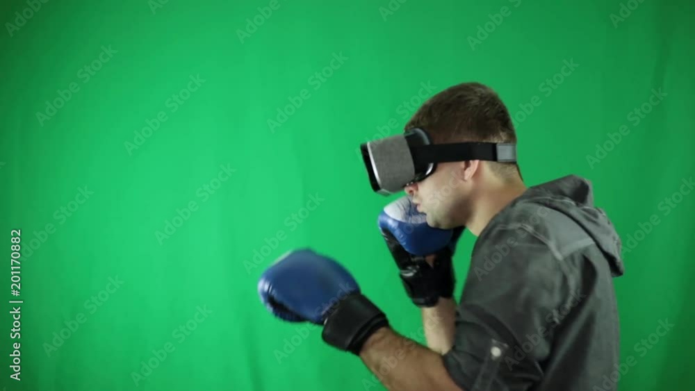 A man in VR glasses and boxing gloves. A man in VR glasses and boxing gloves.