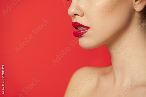 red glossy lipstick on red background