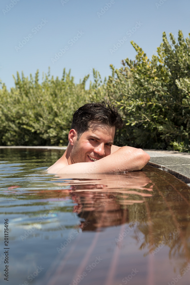 Portrait of young smiling man relaxing in swimming pool Portrait of young smiling man relaxing in swimming pool