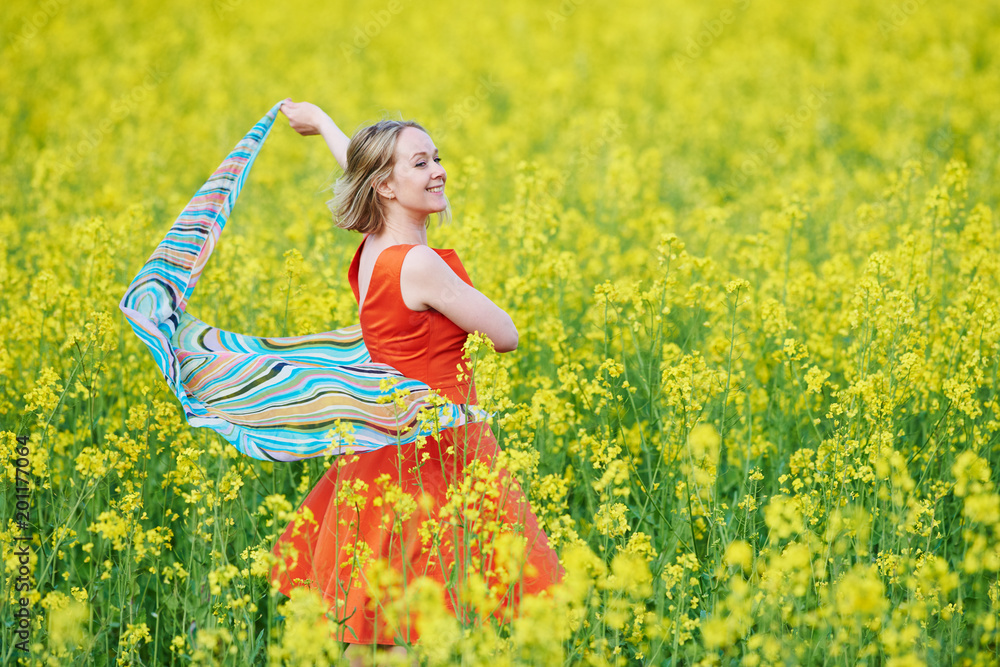 Fototapeta premium Spring and freedom. woman at yellow rape seed meadow