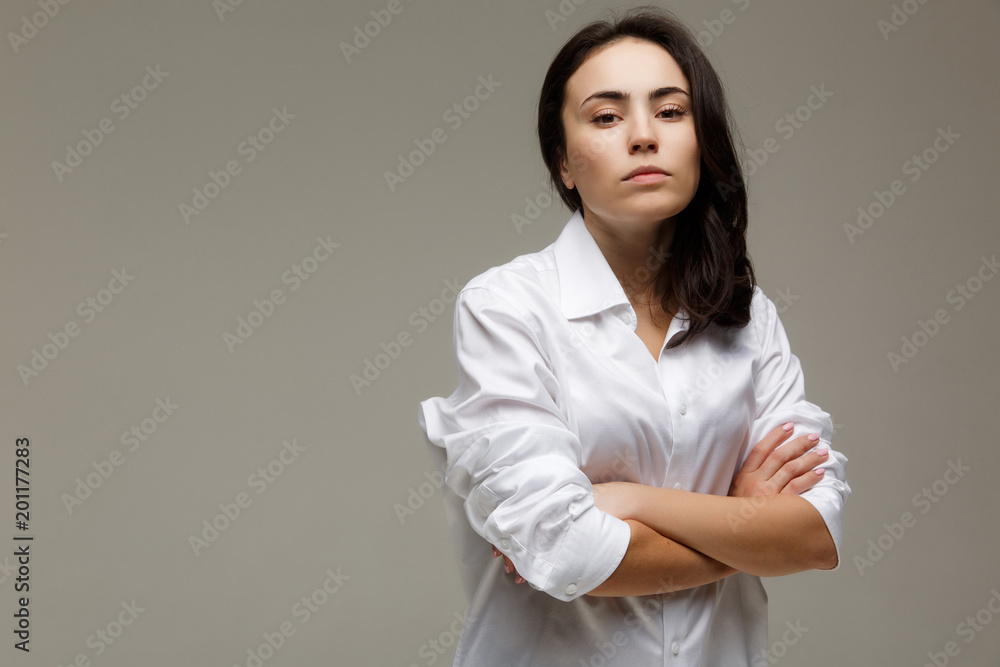 Beautiful girl in a white shirt shows emotions - disorder. On a light background. Beautiful girl in a white shirt shows emotions - disorder. On a light background.