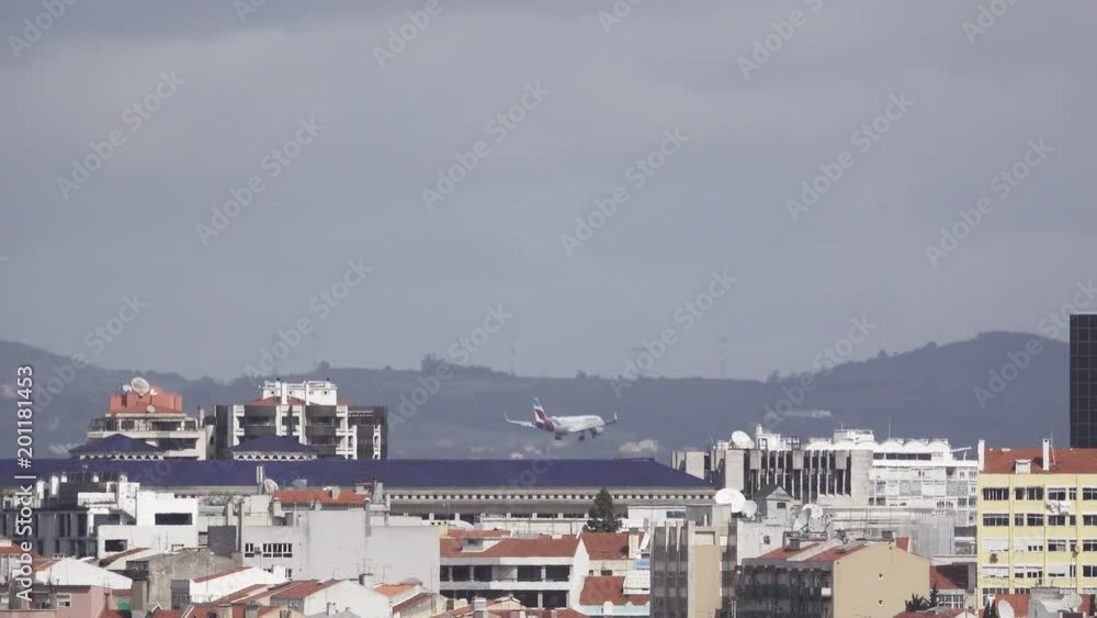Jet landing behind buildings, long shot Jet landing behind buildings, long shot