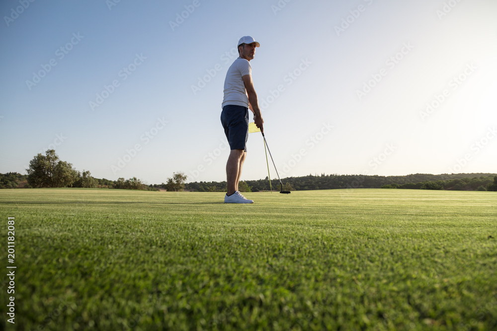 Young golf player watching stroke after the hit Young golf player watching stroke after the hit