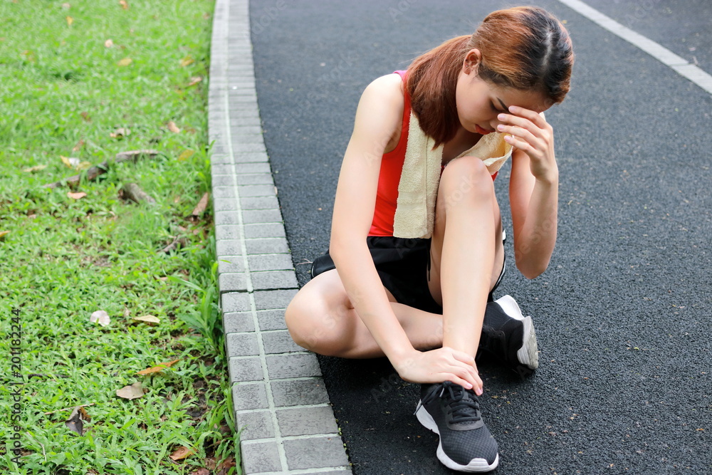 Young Asian fitness woman runner suffering from broken twisted ankle ...
