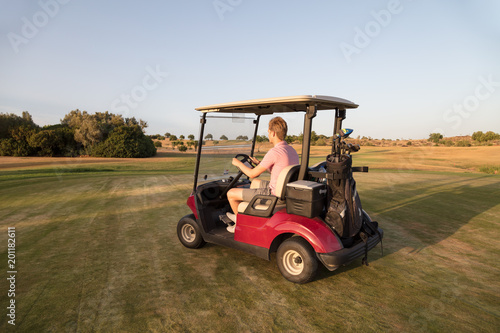 Golfer driving a golf cart on the golf course