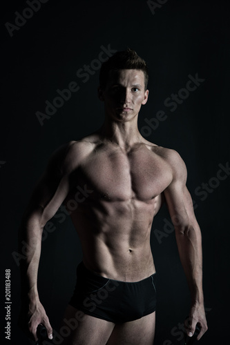 Macho with sexy torso and chest. Man bodybuilder with fit body. Sportsman with six pack and ab muscles. Training and workout activity in gym. Sport fitness and bodycare concept in vintage style