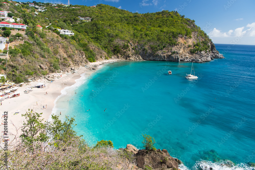 Sea beach with blue water, white sand and mountain landscape in gustavia, st.barts. Summer vacation on tropical beach. Recreation, leisure and relax concept. Wanderlust and travel with adventure Sea beach with blue water, white sand and mountain landscape in gustavia, st.barts. Summer vacation on tropical beach. Recreation, leisure and relax concept. Wanderlust and travel with adventure