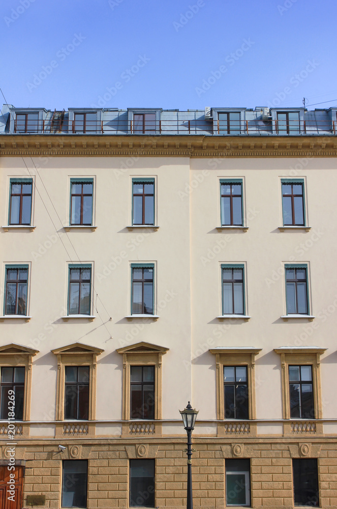 Modern Style Old Building Classical Architecture. Facade of Old Historical Minimalist House with Beige Walls. Apartment and Office Building Exterior Front View with Simple Square Windows in Row.