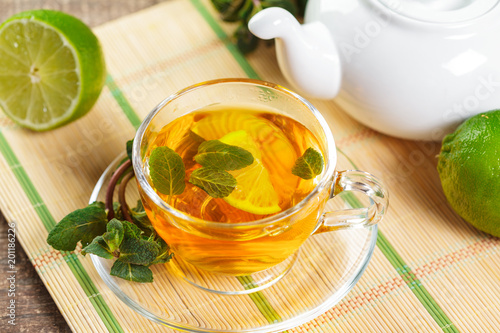 cup of black tea with mint leaves on a wooden table