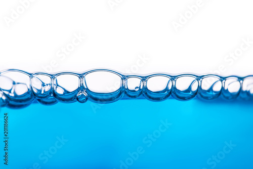 Oxygen bubbles in clear blue water, close-up. Mineral water. Water enriched with oxygen.