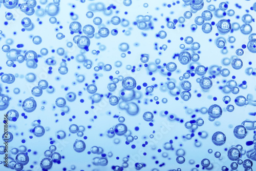 Oxygen bubbles in clear blue water  close-up. Mineral water. Water enriched with oxygen.