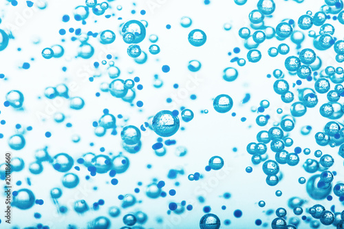 Oxygen bubbles in clear blue water, close-up. Mineral water. Water enriched with oxygen.