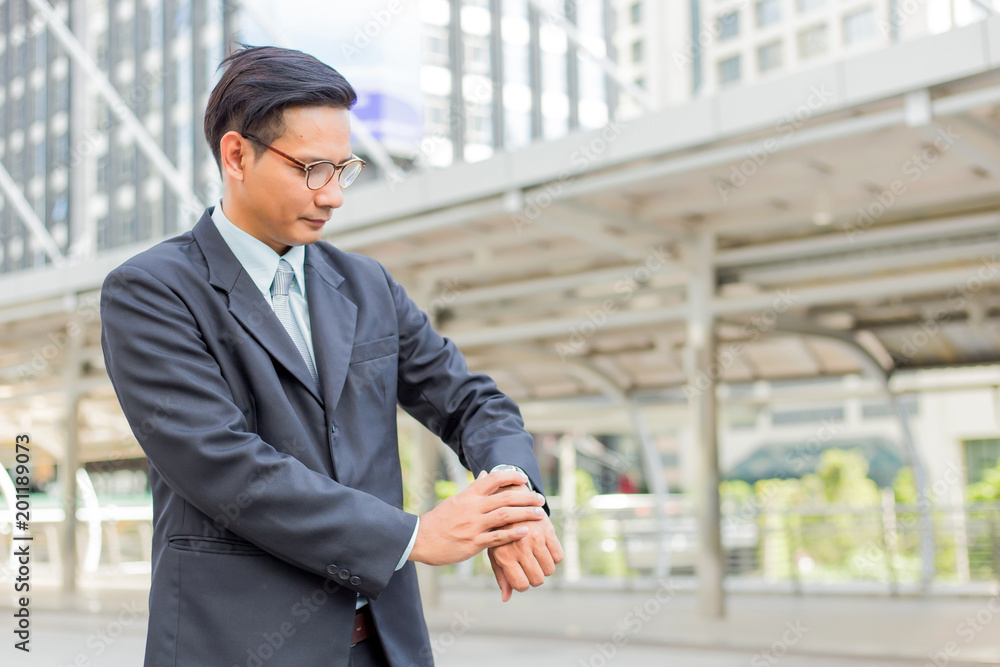 Young Asia handsome businessman looking at his watch Young Asia handsome businessman looking at his watch