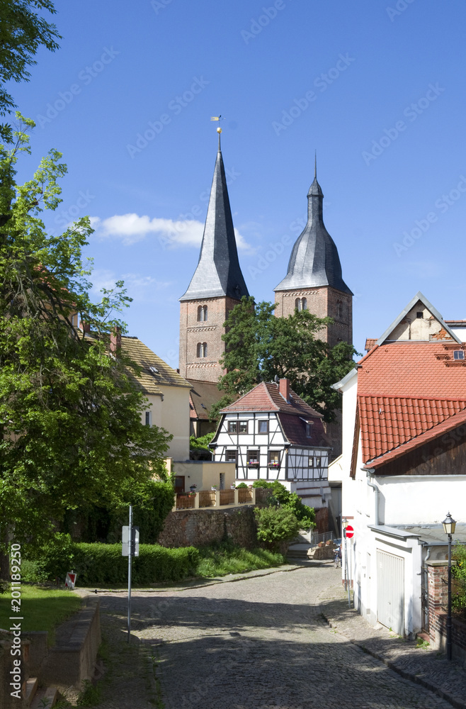 Altenburg / Germany: Historic cobblestone road with an old timbered house in front of the so called Red Spires of the former collegiate church of the Virgin Mary