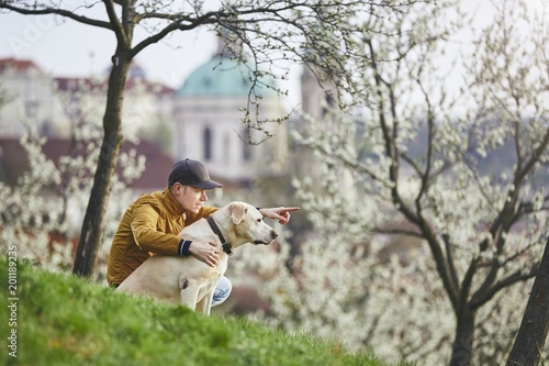 Man with dog in spring public park © Chalabala
