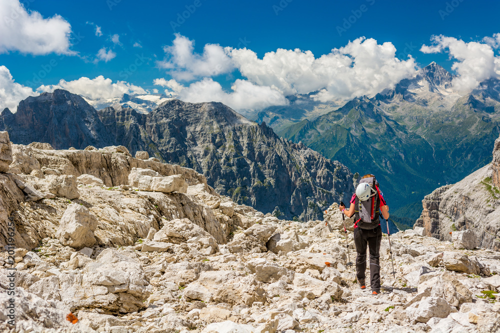 Naklejka premium Female trekker walking along mountain valley.