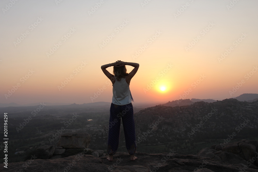 The girl at sunset. The girl stands with her back on the top of the ...