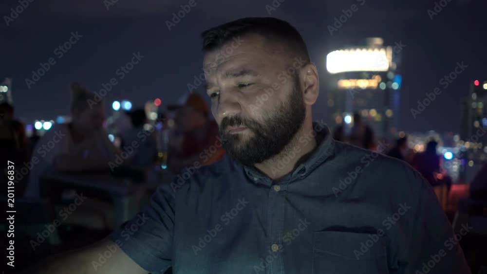 Pensive, young man sitting in skybar at night
Pensive, young man sitting in skybar at night