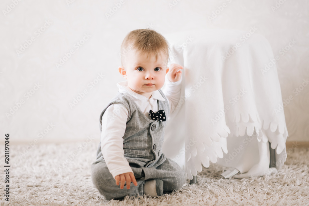 Cute happy baby boy in stylish gentleman suit sitting on white background Cute happy baby boy in stylish gentleman suit sitting on white background