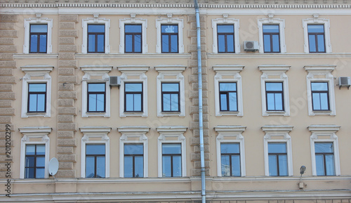 Building Facade Classic Architecture with Windows in Row. Symmetric Old Historical Minimalist House with Soft Beige and Brown Stoned Walls. Exterior Front View of Traditional City Center Building.