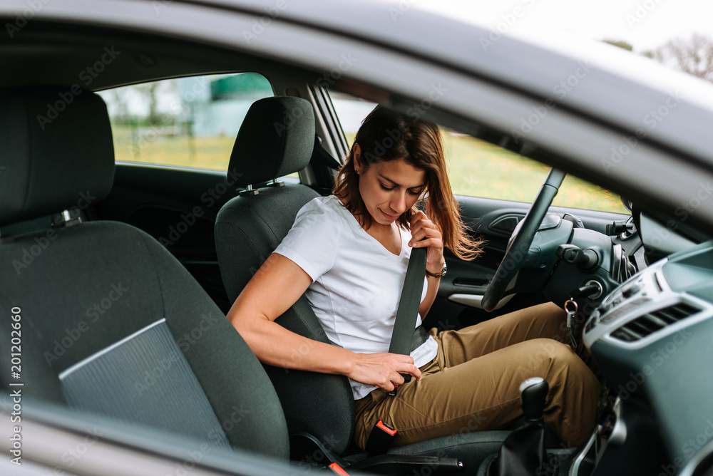 Safety first. Beautiful caucasian lady fastening car seat belt. Safety first. Beautiful caucasian lady fastening car seat belt.