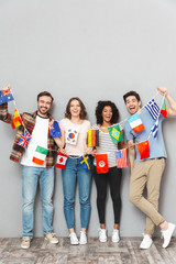 Happy group of friends holding a lot of international flags.