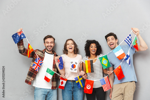 Happy group of friends holding a lot of international flags. photo