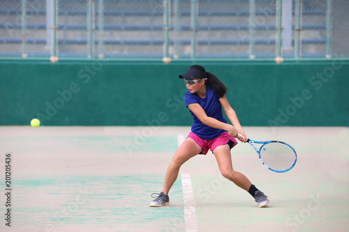 バックハンドを打つ女子ジュニアテニスプレイヤー © DOUBLE BAGEL