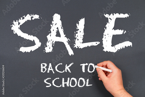 hand writing by white chalk on a blackboard. Back to school sale.