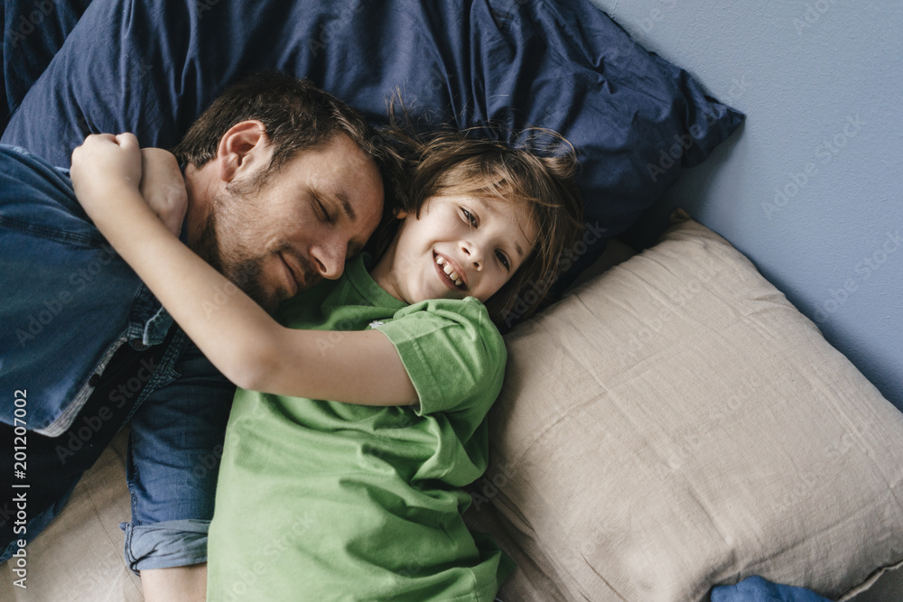 Father and son cuddling at home Father and son cuddling at home