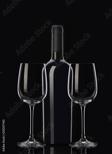 Bottle of red wine and two glasses on black background