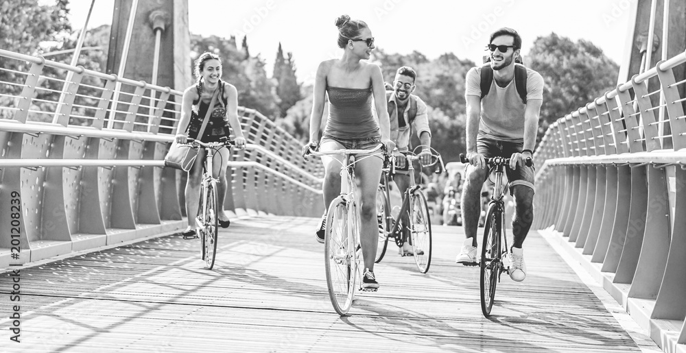 Obraz premium Happy friends riding bicycles in summer around the city