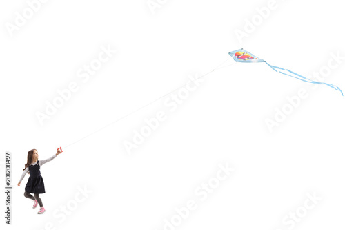Little girl running and flying a kite