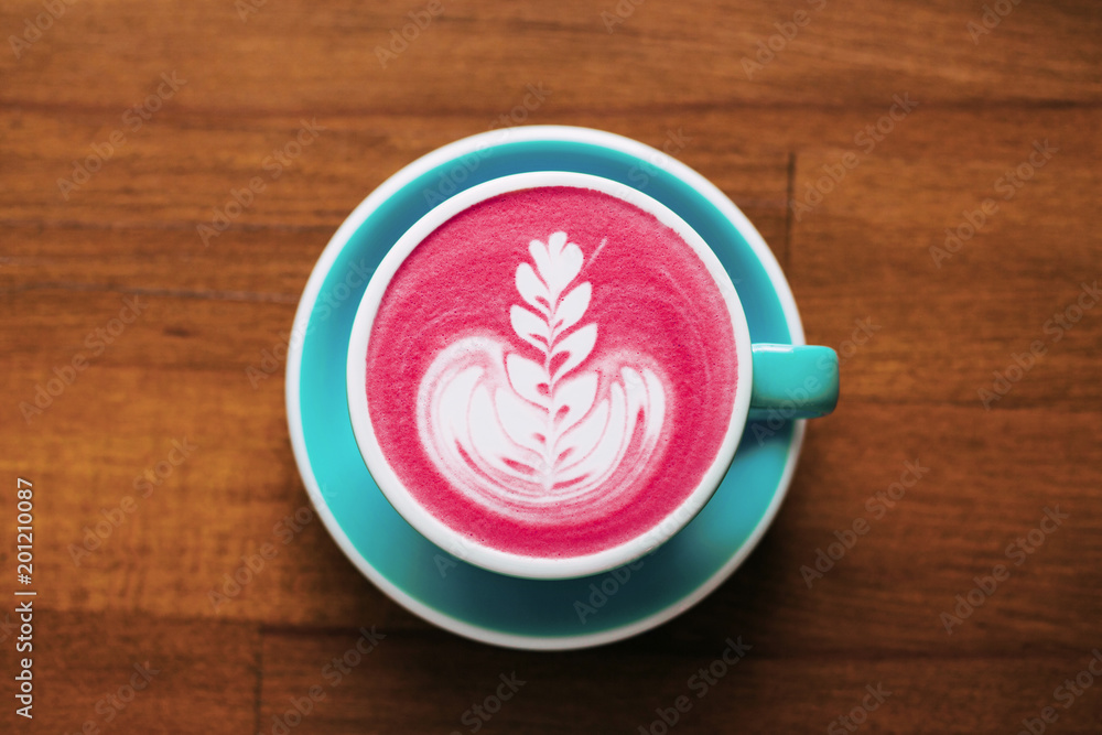 Healthy trendy beetroot latte with latte art in ceramic cup on wooden table. Top view. Healthy trendy beetroot latte with latte art in ceramic cup on wooden table. Top view.