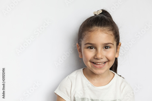 Fototapeta Portrait of happy cute brunette child  girl on white background