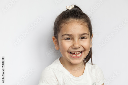 Portrait of happy cute brunette child girl on white background