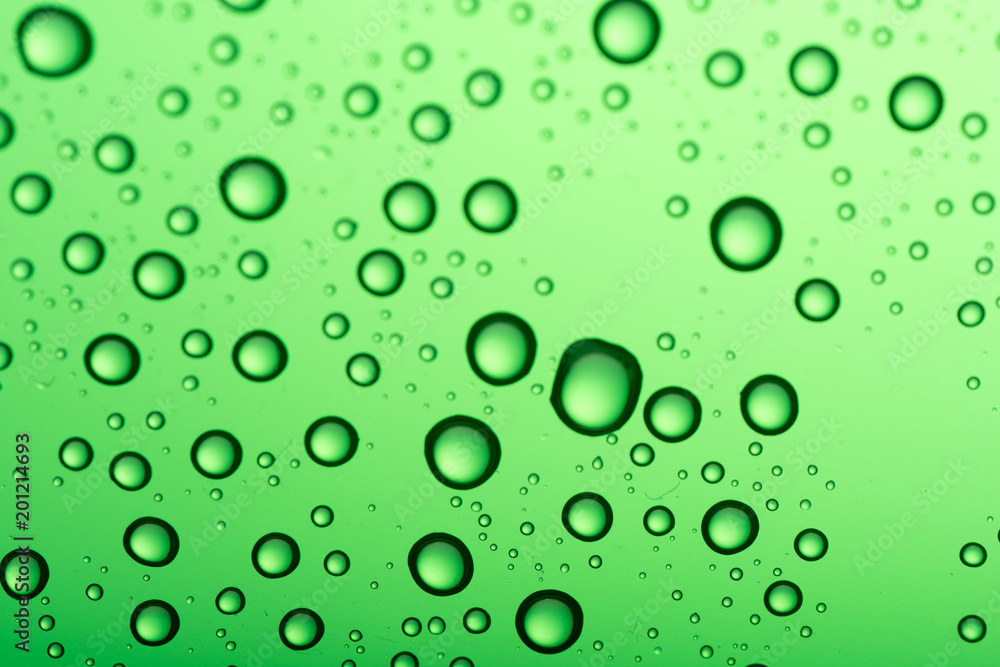 Drops of water on a color background. Green tone