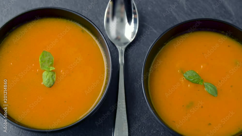 food, eating and new nordic cuisine concept - close up of hands putting second bowl of pumpkin cream soup on kitchen table food, eating and new nordic cuisine concept - close up of hands putting second bowl of pumpkin cream soup on kitchen table