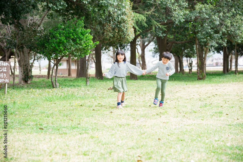 手を繋いで歩く笑顔の子供 手を繋いで歩く笑顔の子供