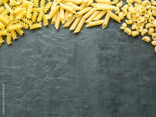 Background of dry Italian pasta spaghetti, Fusilli and macaroni. Copy space
