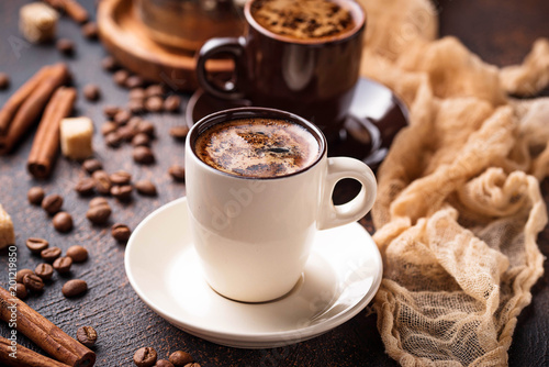 Cups of coffee, beans, sugar and cinnamon