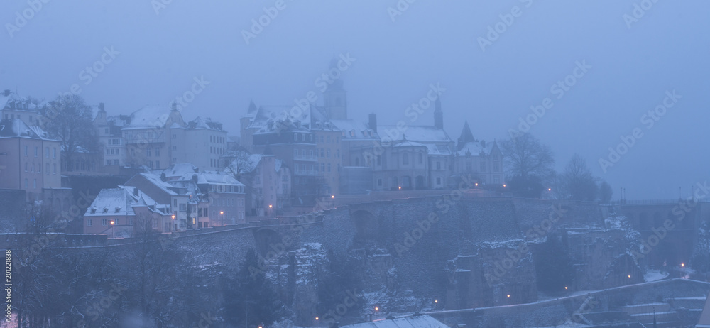 Luxembourg city enveloped in early morning fog and covered in snow