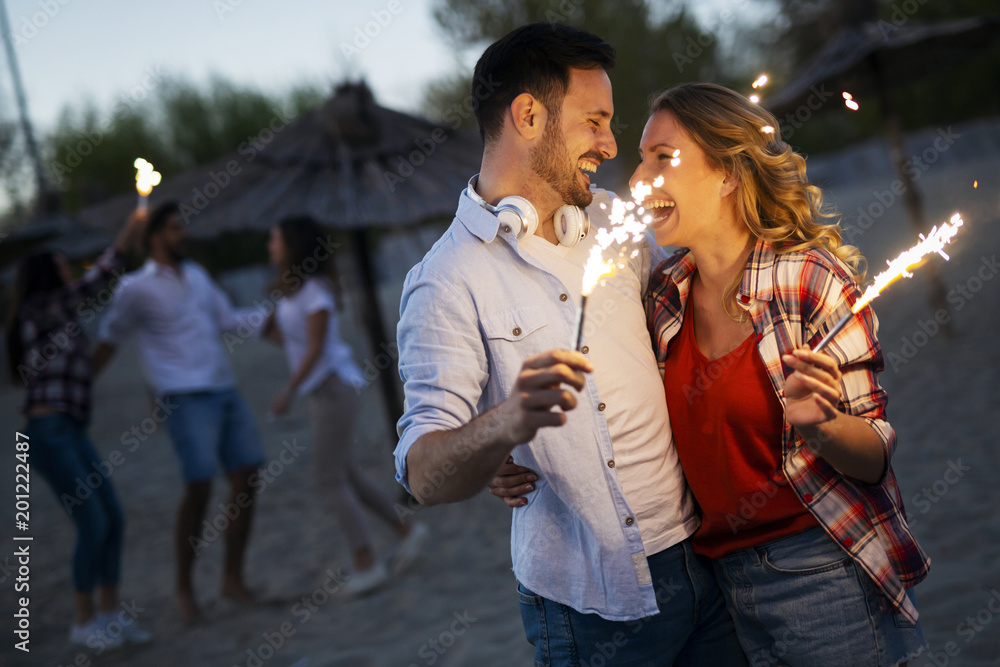 Fototapeta premium Picture of happy couple holding burning sparkle