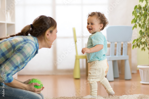 Mother is joying while little baby boy running to her photo